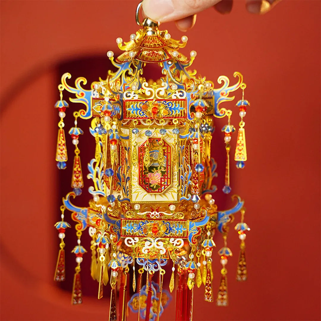 Hand holding the top of the palace lantern to show its detailed metal decoration